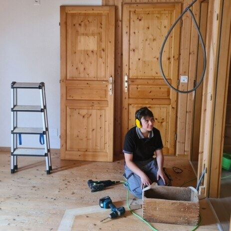 Schreiner beim Einbau einer alten Holztür