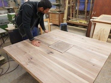 Schreiner an einer Tischplatte in der Werkstatt